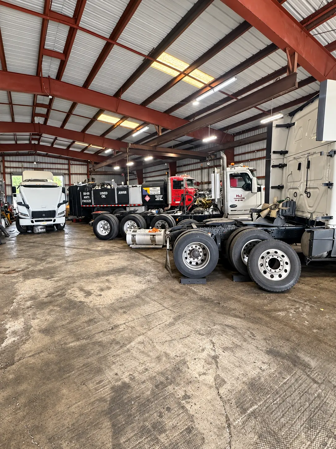 Semi-trucks parked inside the shop's repair bays
